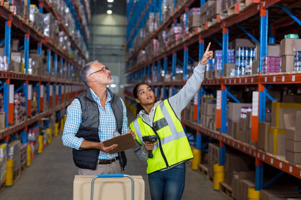 Distribuidor y empleado de almacén revisando el inventario